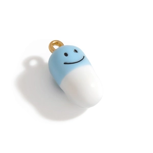 Détail du pendentif capsule bleu et blanc avec sourire et fermoir doré chic