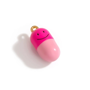 Détail macro d'un pendentif capsule rose avec sourire pour bijoux et sacs DIY