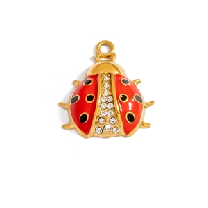 Macro detail of ladybug pendant with red enamel, black dots and crystal rhinestones