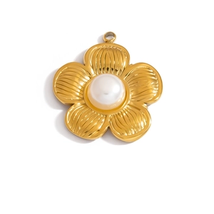 Detailed macro of gold flower pendant featuring white pearl center and ribbed petals