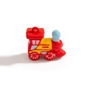Détail d'une breloque de train en émail rouge avec fenêtres colorées pour bijoux DIY