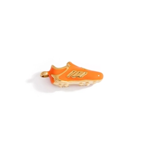 Detail of a soccer shoe pendant in gold metal and orange enamel with a secure hanging loop