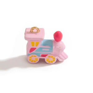 Gros plan d'un pendentif petit train rose avec anneau doré pour bijoux DIY