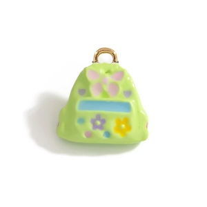 Vue macro d'un pendentif cartable en émail vert avec de petits détails floraux