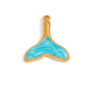 Macro shot of gold-plated whale tail pendant with blue marbled enamel inlay