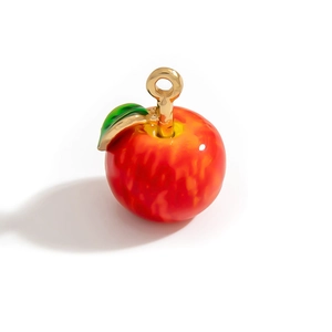 Pendentif pomme rouge émaillé avec tige dorée et feuille verte sur fond blanc pur
