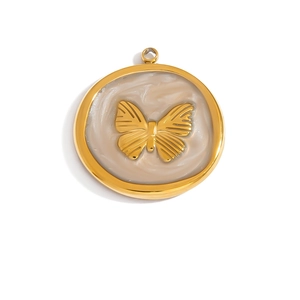 Macro detail of a golden butterfly pendant with marble texture inlay and polished metal ring