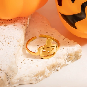 Minimalist gold stainless steel open pumpkin ring for Halloween on white stone background