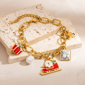 Golden Christmas bracelet with reindeer and Santa charms on white travertine stones