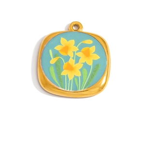 Close-up of gold 18K pendant with light blue enamel and yellow daffodil floral pattern