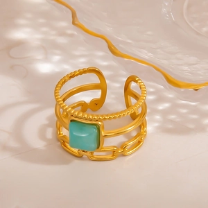 Detail of adjustable gold ring with turquoise stone and three-layer vintage textured bands
