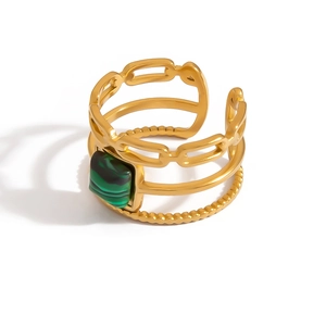 Detail view of multi-layer gold ring with textured bands and square green stone inlay