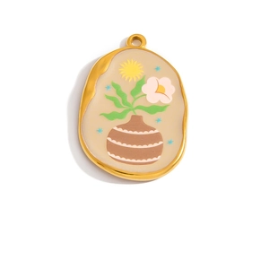 Macro detail of oval pendant with golden frame featuring floral vase and sun enamel design