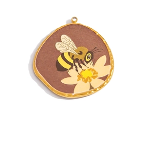 Close-up of 18K gold-plated bee and floral round pendant for DIY jewelry crafting