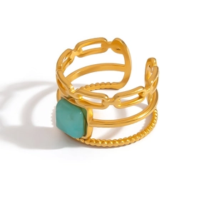 Detail of gold layered ring with square turquoise stone and beaded metal textures