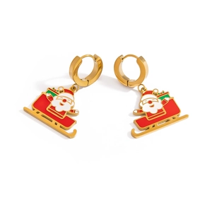 Detail of golden Christmas earrings with red Santa Claus on a sleigh pendant charm