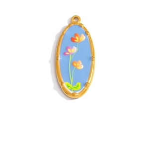 Detailed macro view of an oval floral pendant with gold plating and blue enamel finish
