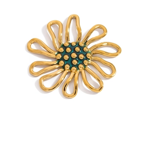 Macro view of gold flower pendant with green center and golden bead accents