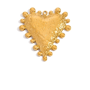 Macro shot of gold heart pendant with hammered texture and beaded edge design