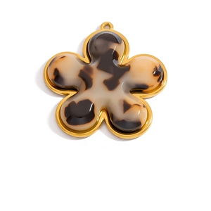 Macro detail of 18K gold-plated flower pendant with tortoise shell resin inlay and loop