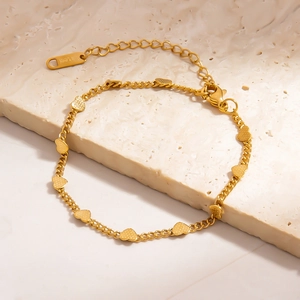 Detailed close-up of a 18K gold-plated stainless steel bracelet with small heart charms