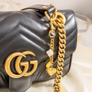 Sac bandoulière en cuir matelassé noir avec chaîne dorée et breloques de fruits d'été