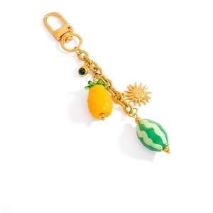 Détail d'un porte-clés plaqué or 18K avec pendentif ananas et soleil sur fond blanc