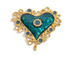 Detailed macro view of vintage heart pendant with turquoise enamel and blue gemstone inlay
