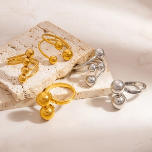 Minimalist stainless steel ball rings in gold and silver finish on stone display