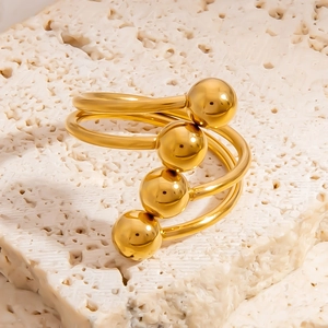 Detailed macro view of an 18K gold-plated stainless steel spiral ring with four beads
