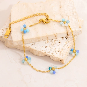 Bracelet en acier inoxydable plaqué or 18 carats avec breloques marguerites bleues