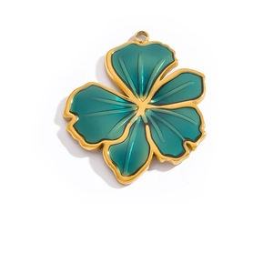 Detailed close-up of a five-petal flower pendant with gold edges and green enamel inlay