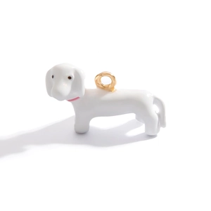 Macro detail of white enamel dachshund pendant charm with 18K gold plated ring
