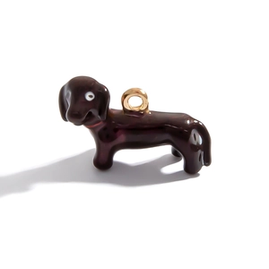 Detailed close-up of a dark brown dachshund charm with glossy enamel and gold metal ring