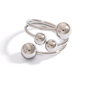 Detailed view of polished spiral ring with silver metal spheres on white background