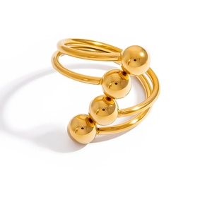 Detailed view of multilayer 18K gold plated spiral ring with four metallic spheres