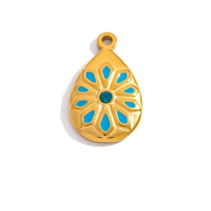 Detailed view of teardrop pendant with blue enamel flower and green gemstone center