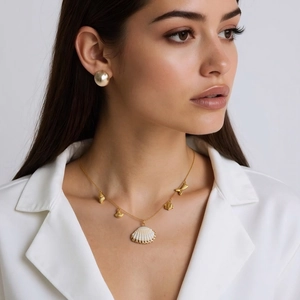 Détail de collier en acier doré 18K avec pendentifs coquillages et boucles d'oreilles rondes
