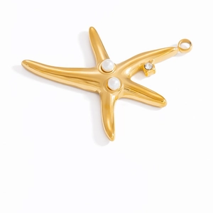 Détail d'un pendentif étoile de mer doré 18 carats avec perles blanches et strass brillant