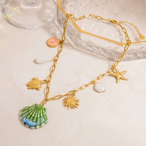 Close-up of golden titanium necklace with seashell, sea turtle, and starfish charms