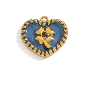 Macro detail of heart-shaped 18K gold pendant with blue enamel clover design