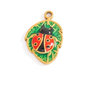 Detailed macro view of ladybug on green leaf pendant in 18K gold plated enamel