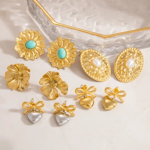 Detalle de set de 5 pares de pendientes con perlas, lazos y girasoles en acabado de oro 18K