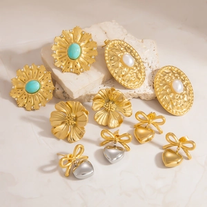 Colección de pendientes dorados con perlas de girasol y colgantes de corazón en mármol