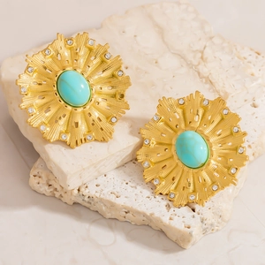 Detalle de pendientes chapados en oro con piedra turquesa y acentos de diamantes