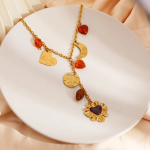 Vintage gold stainless steel necklace with sun, moon, and amber charms on satin cloth