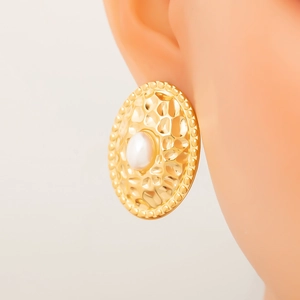 Detalle de pendiente de flor irregular chapado en oro de 18K con textura martillada