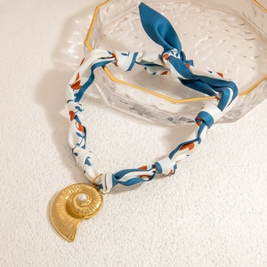 18K gold plated conch nautilus shell scarf necklace with pearl on glass tray