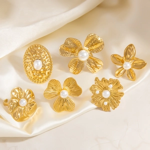 Detail shot of vintage 18K gold plated rings set with floral motifs and white pearls