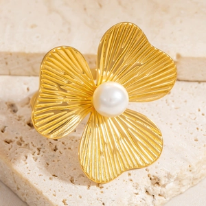 Detailed close-up of 18K gold-plated flower ring with center pearl and radial texture